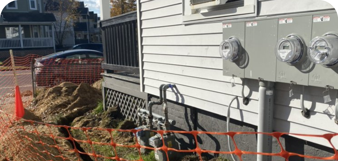 Blocked off construction zone by house with electrical panels on side of house